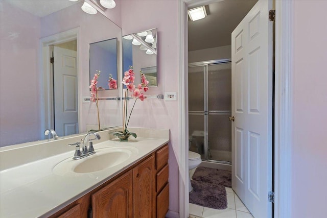 bathroom with a shower with shower door, toilet, vanity, and tile patterned flooring