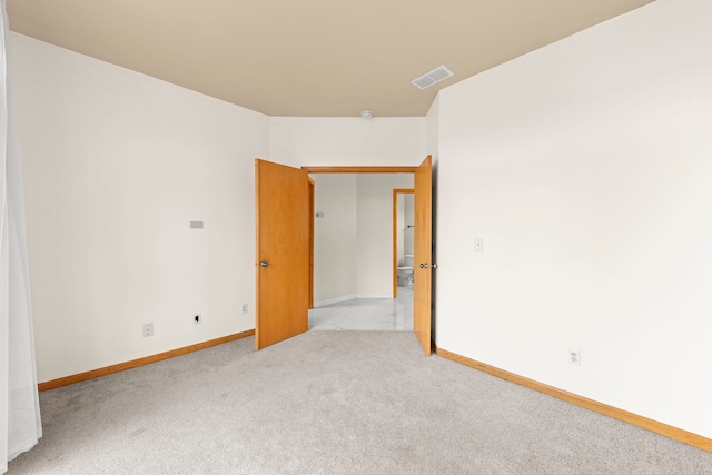 empty room with carpet floors, visible vents, and baseboards