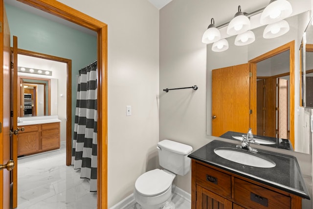 bathroom featuring marble finish floor, baseboards, vanity, and toilet