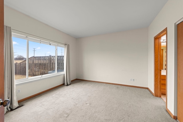 carpeted spare room with visible vents and baseboards