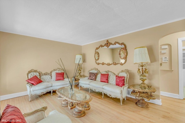 living room featuring ornamental molding, hardwood / wood-style floors, and a textured ceiling