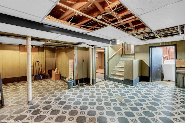 basement featuring washer / dryer and wood walls