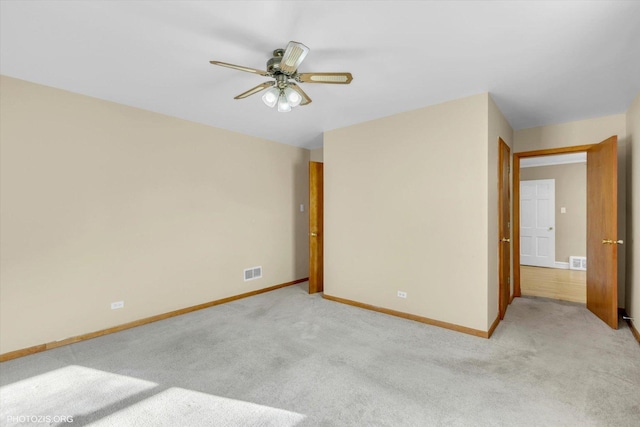 carpeted spare room featuring ceiling fan