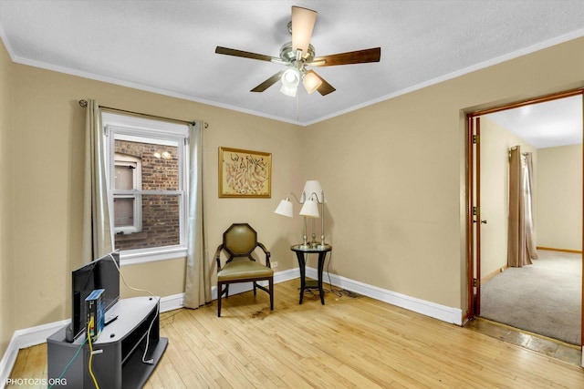 sitting room featuring ceiling fan, ornamental molding, light hardwood / wood-style flooring, and plenty of natural light