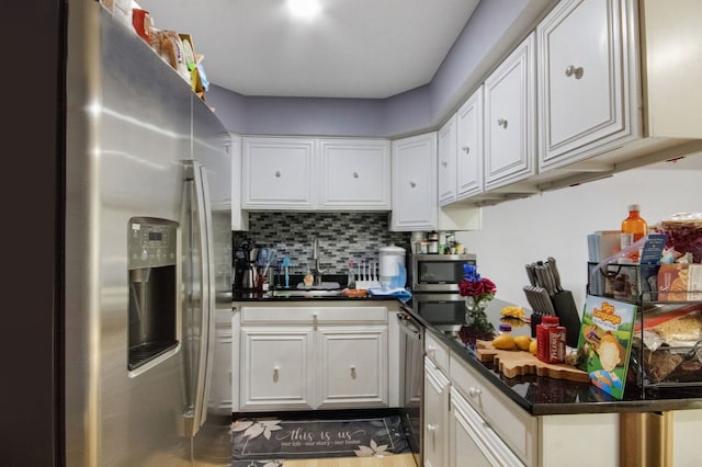 kitchen featuring decorative backsplash, white cabinets, and appliances with stainless steel finishes