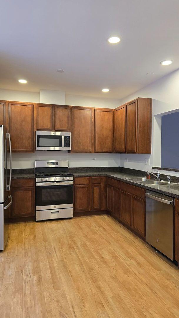 kitchen featuring sink, light hardwood / wood-style floors, and stainless steel appliances