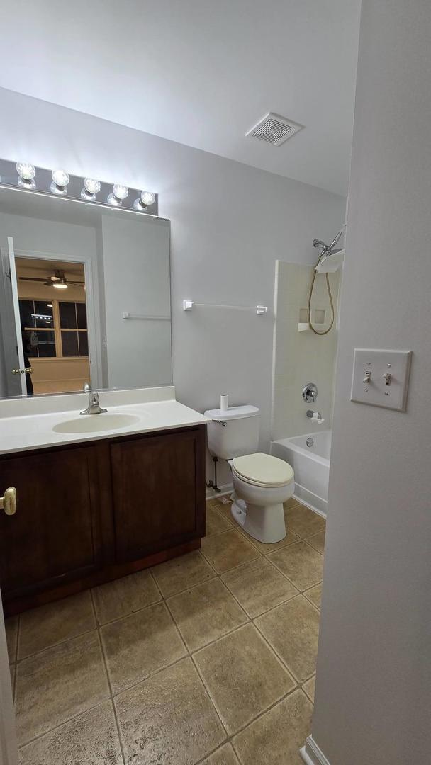 full bathroom featuring toilet, tile patterned floors, vanity, ceiling fan, and tub / shower combination