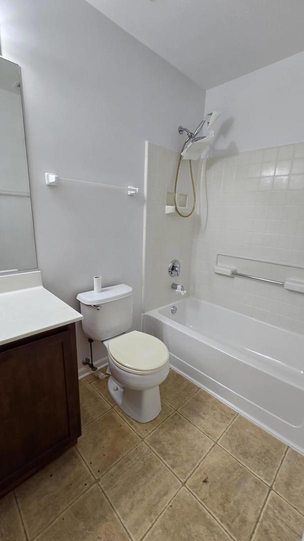 full bathroom with tub / shower combination, tile patterned floors, toilet, and vanity