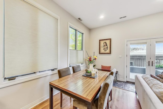 dining space with french doors and light hardwood / wood-style flooring