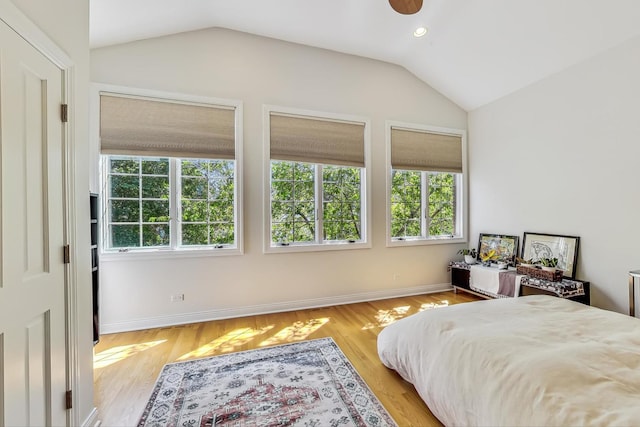 bedroom with light hardwood / wood-style floors, multiple windows, and lofted ceiling