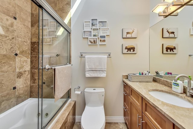 full bathroom with vanity, bath / shower combo with glass door, and toilet