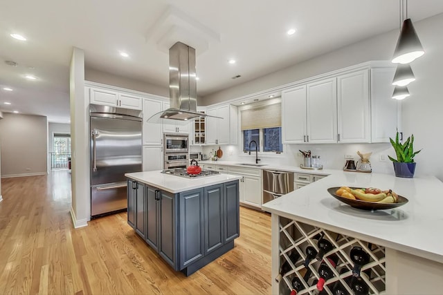 kitchen featuring sink, built in appliances, decorative light fixtures, a kitchen island, and island exhaust hood