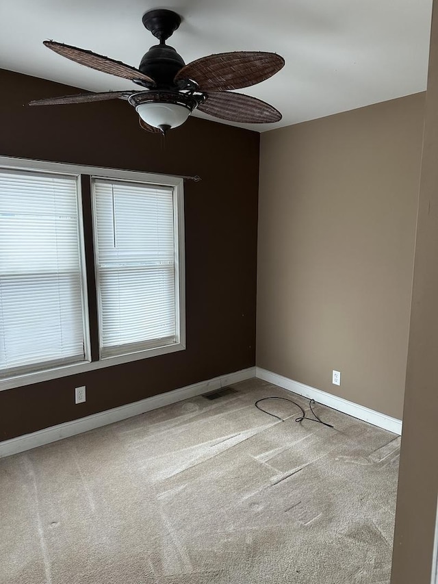 carpeted spare room with ceiling fan