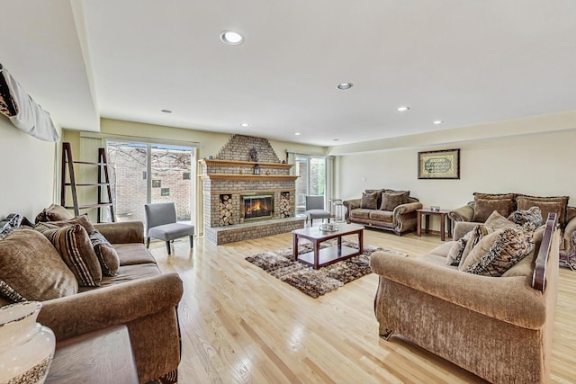 living room with a healthy amount of sunlight, light hardwood / wood-style flooring, and a fireplace