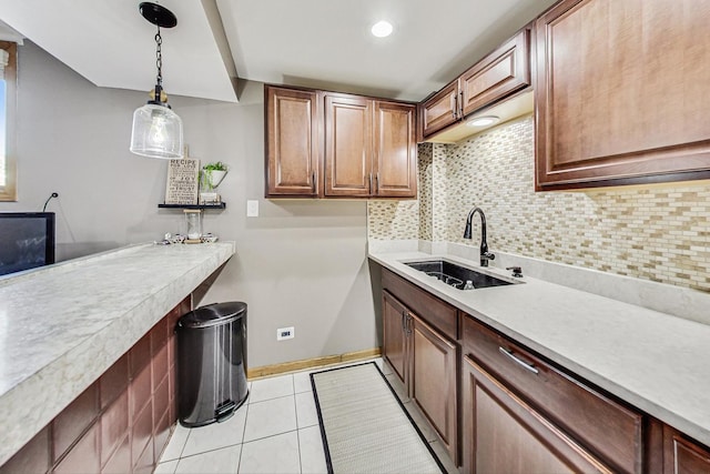 kitchen featuring sink, tasteful backsplash, light tile patterned floors, and pendant lighting