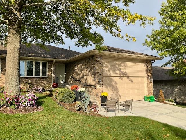 back of property featuring a lawn and a garage