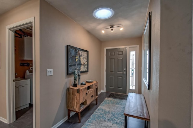 entrance foyer with rail lighting and dark tile patterned floors