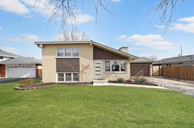 split level home featuring a garage and a front lawn