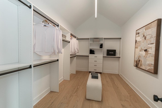 spacious closet with light hardwood / wood-style flooring and vaulted ceiling