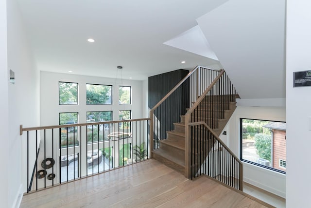 staircase with hardwood / wood-style flooring and a healthy amount of sunlight