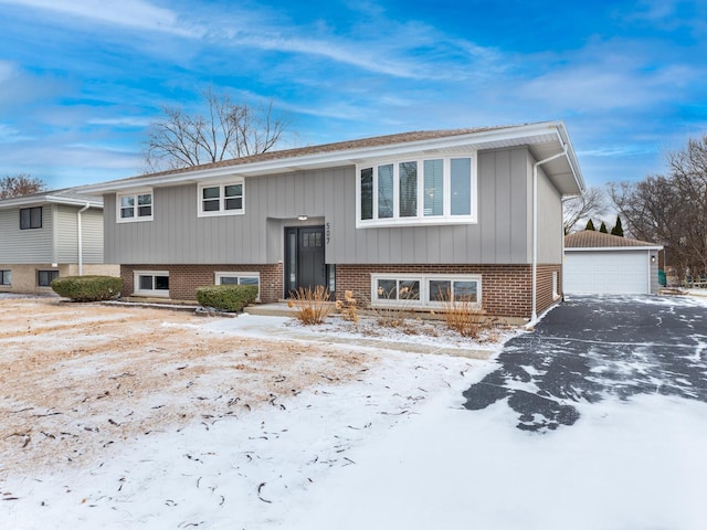 raised ranch featuring a garage and an outbuilding