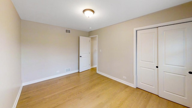 unfurnished bedroom with a closet and light hardwood / wood-style flooring