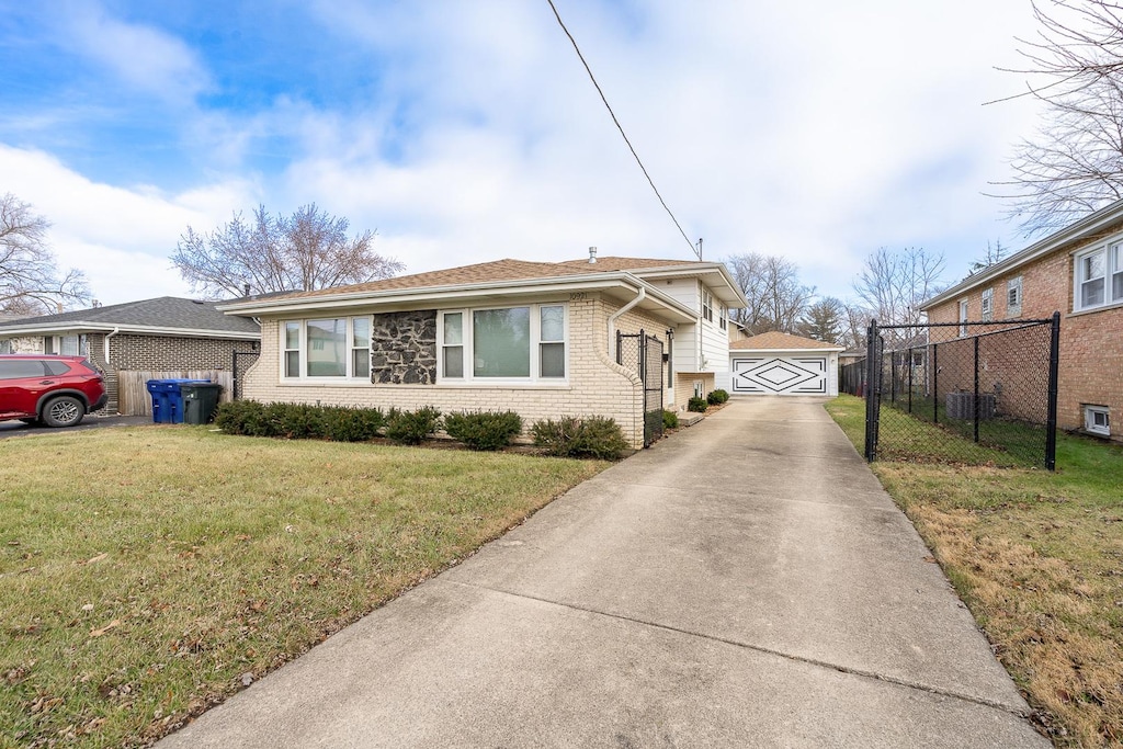 view of front of home featuring a garage, central air condition unit, an outbuilding, and a front lawn