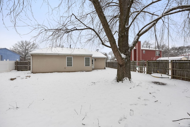 view of snow covered back of property