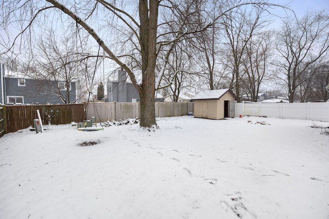 yard layered in snow with a storage unit