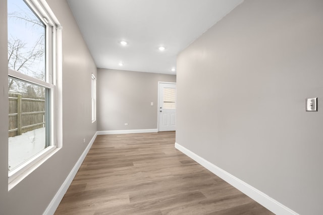 hallway featuring light wood-type flooring and plenty of natural light