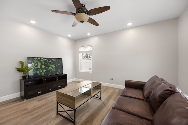 living room featuring light hardwood / wood-style flooring and ceiling fan