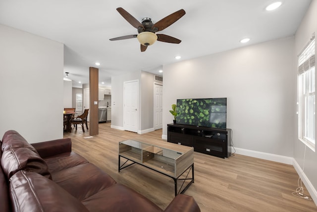 living room featuring ceiling fan and light hardwood / wood-style flooring