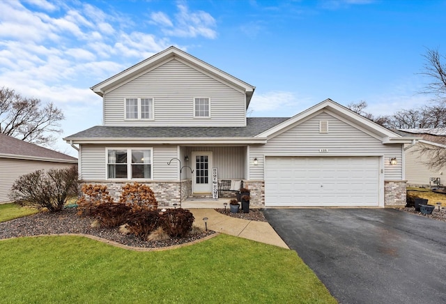 view of property featuring a garage and a front lawn