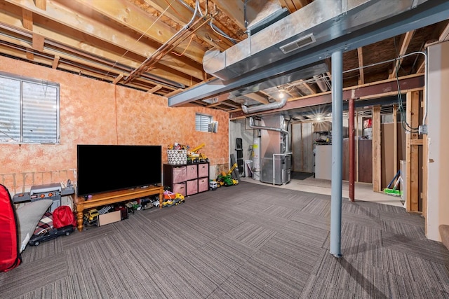 basement featuring dark colored carpet and heating unit