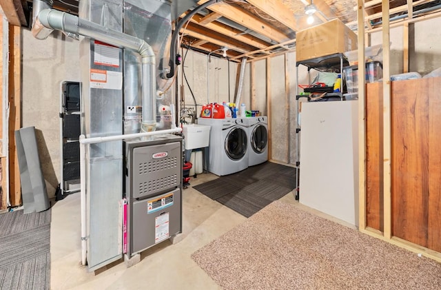 laundry room with washing machine and clothes dryer, sink, and heating unit