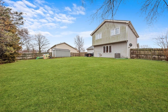 rear view of property featuring a shed, cooling unit, and a yard