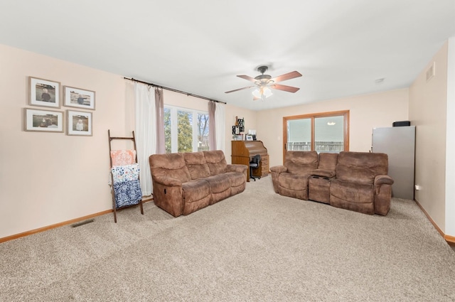 carpeted living room with ceiling fan