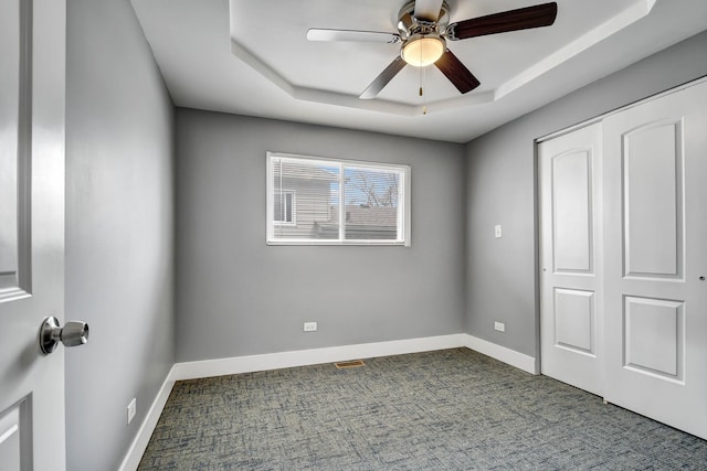 16542 Paulina St, Markham, IL 60428 - unfurnished bedroom featuring visible vents, dark carpet, baseboards, and a tray ceiling