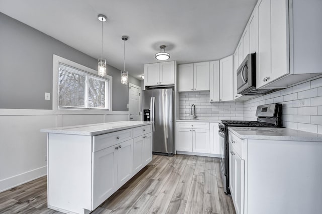 16542 Paulina St, Markham, IL 60428 - kitchen featuring a kitchen island, appliances with stainless steel finishes, white cabinetry, and light wood-style floors