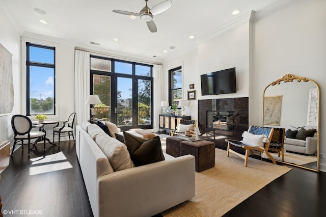 living room with ceiling fan, dark hardwood / wood-style flooring, crown molding, and a wood stove