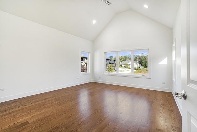 spare room with high vaulted ceiling and dark hardwood / wood-style floors