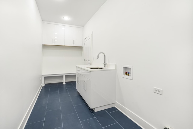 laundry room featuring cabinets, hookup for a washing machine, dark tile patterned floors, and sink