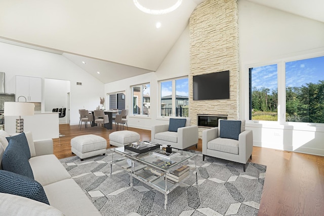 living room with a fireplace, high vaulted ceiling, and wood-type flooring