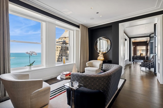 living room featuring dark hardwood / wood-style floors, a healthy amount of sunlight, a water view, and crown molding