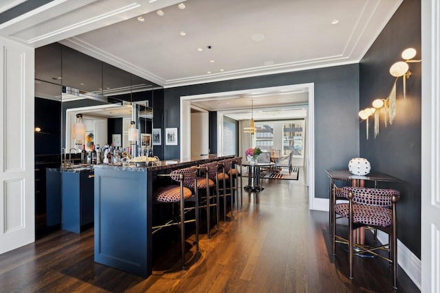 bar featuring dark hardwood / wood-style flooring, hanging light fixtures, and ornamental molding