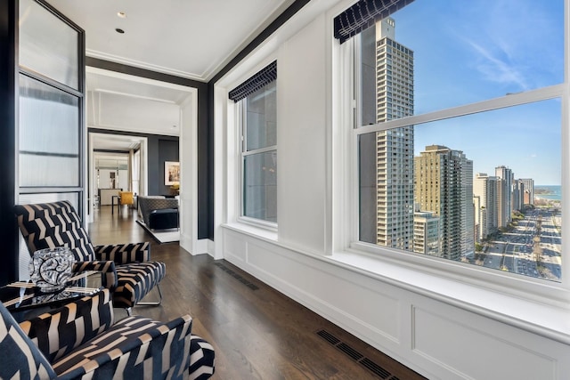 living area with dark hardwood / wood-style flooring and ornamental molding