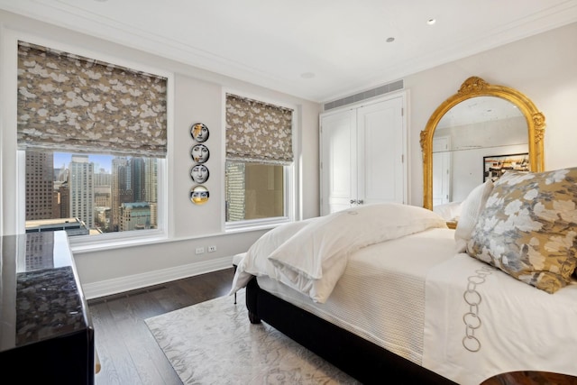 bedroom featuring crown molding, a closet, and dark wood-type flooring