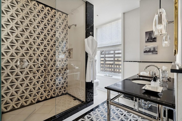 bathroom featuring a shower, dual sinks, tile patterned flooring, toilet, and a wall of windows