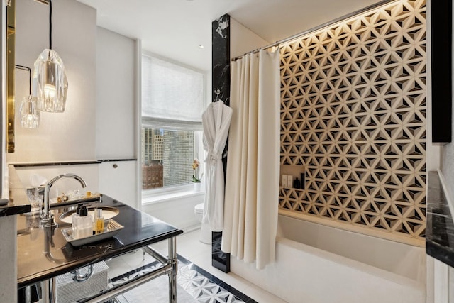 full bathroom featuring sink, shower / bathtub combination with curtain, and toilet