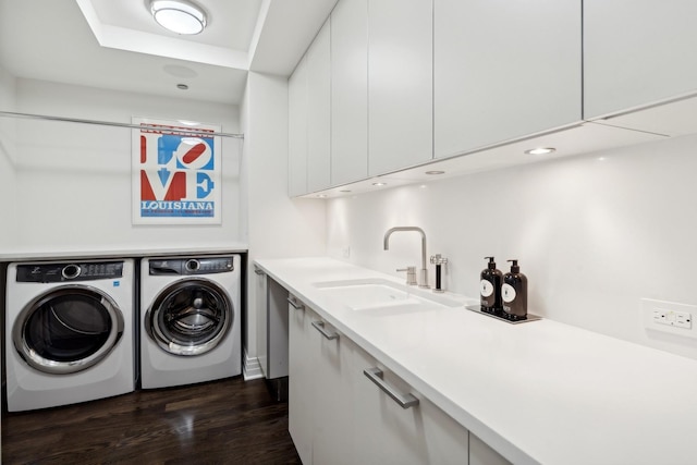 laundry area with dark wood-type flooring, sink, cabinets, and independent washer and dryer